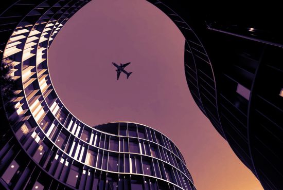 plane flying over building